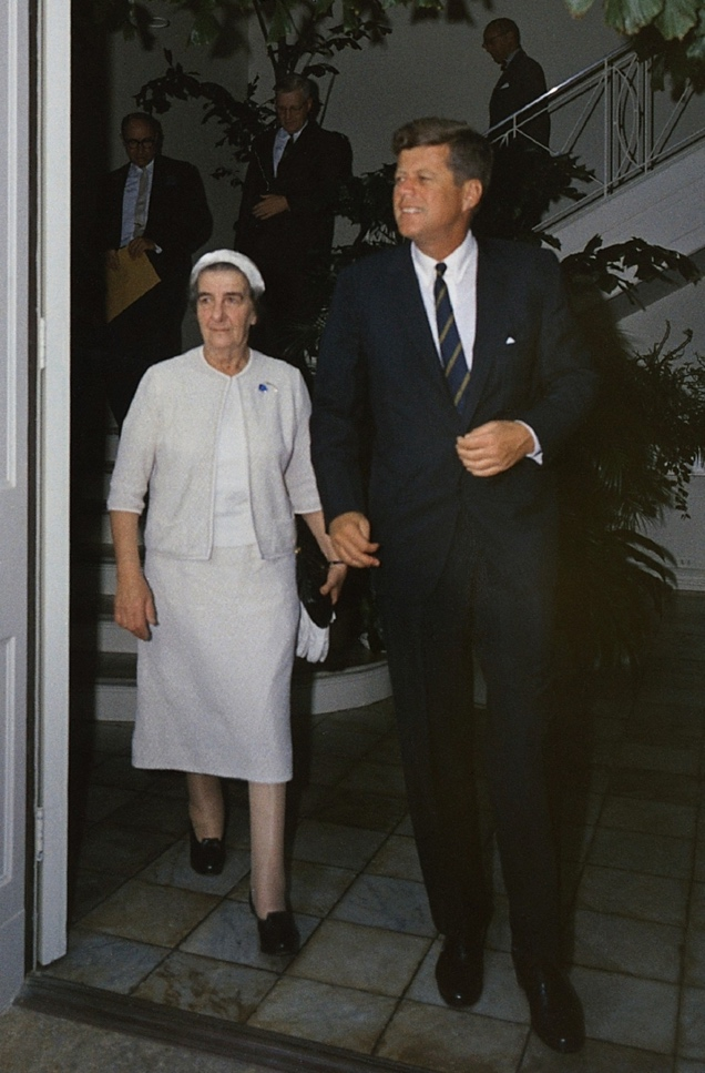 John F. Kennedy Wearing a Suit While Walking with Fairly Older Woman