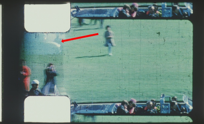 Figure 26. A red arrow points to an example of a ghost motorcycle fender from the prior frame. (Source: Zavada 4K Scan of Frame 312; annotations added)