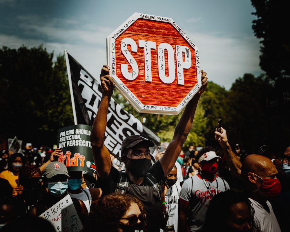 A Man Holding Up a Stop Sign During a BLM Protest