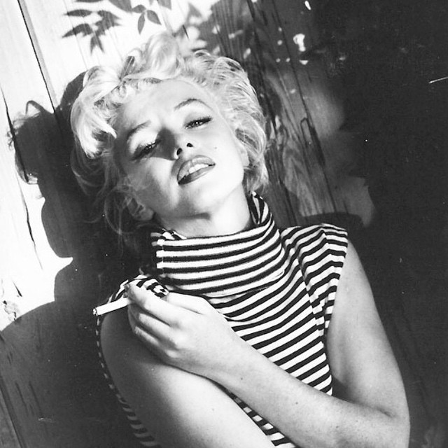 Marilyn Monroe Holding a Cigarette Between Her Fingers