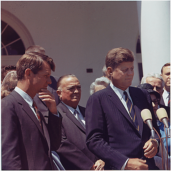 A Colorized Image of John F. Kennedy During a Press Conference Flanked by Robert F. Kennedy Among Other People
