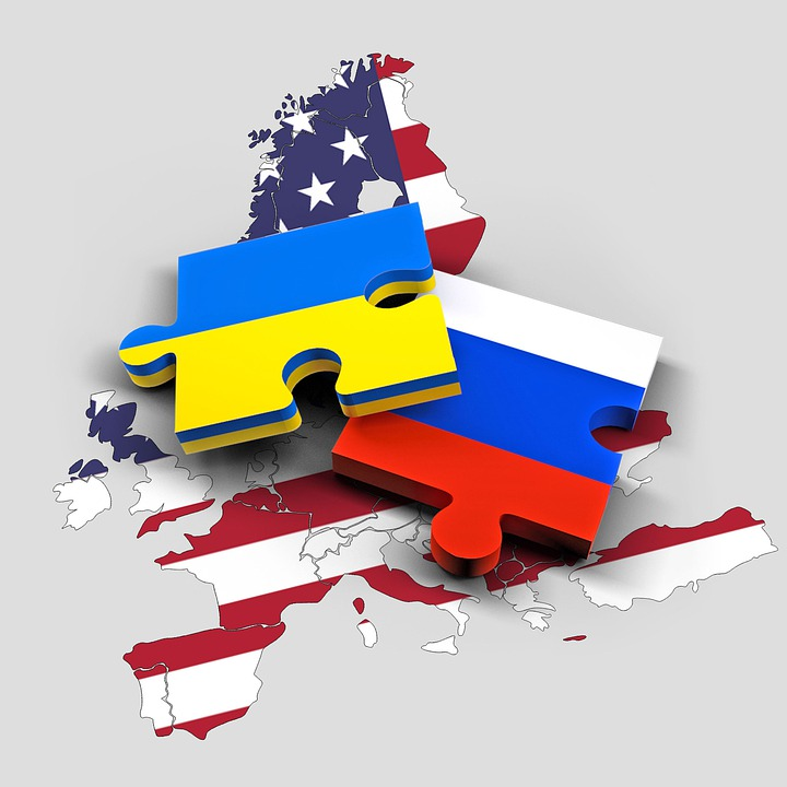 Two Puzzle Pieces Colored Like the Flags of Russia and Ukraine Over the US Flag